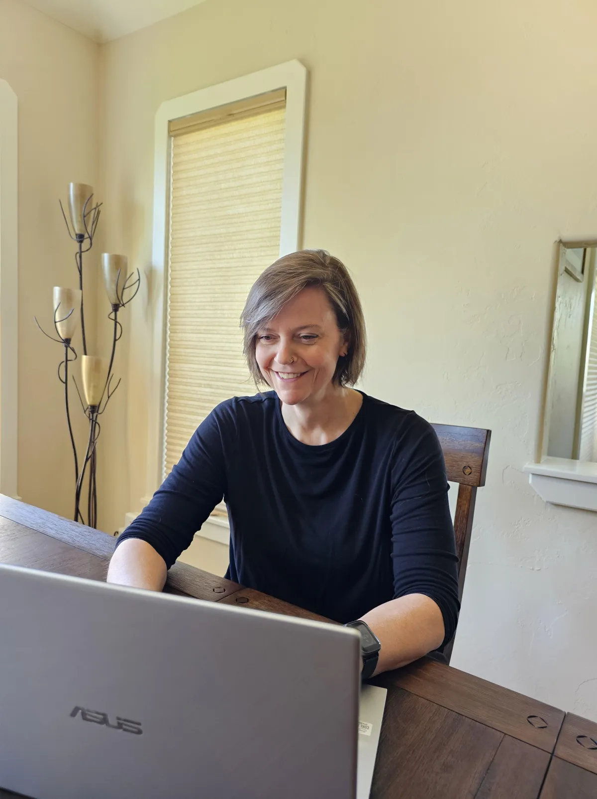 Book coach Maurene Janiece smiling in front of a laptop during a coaching call.