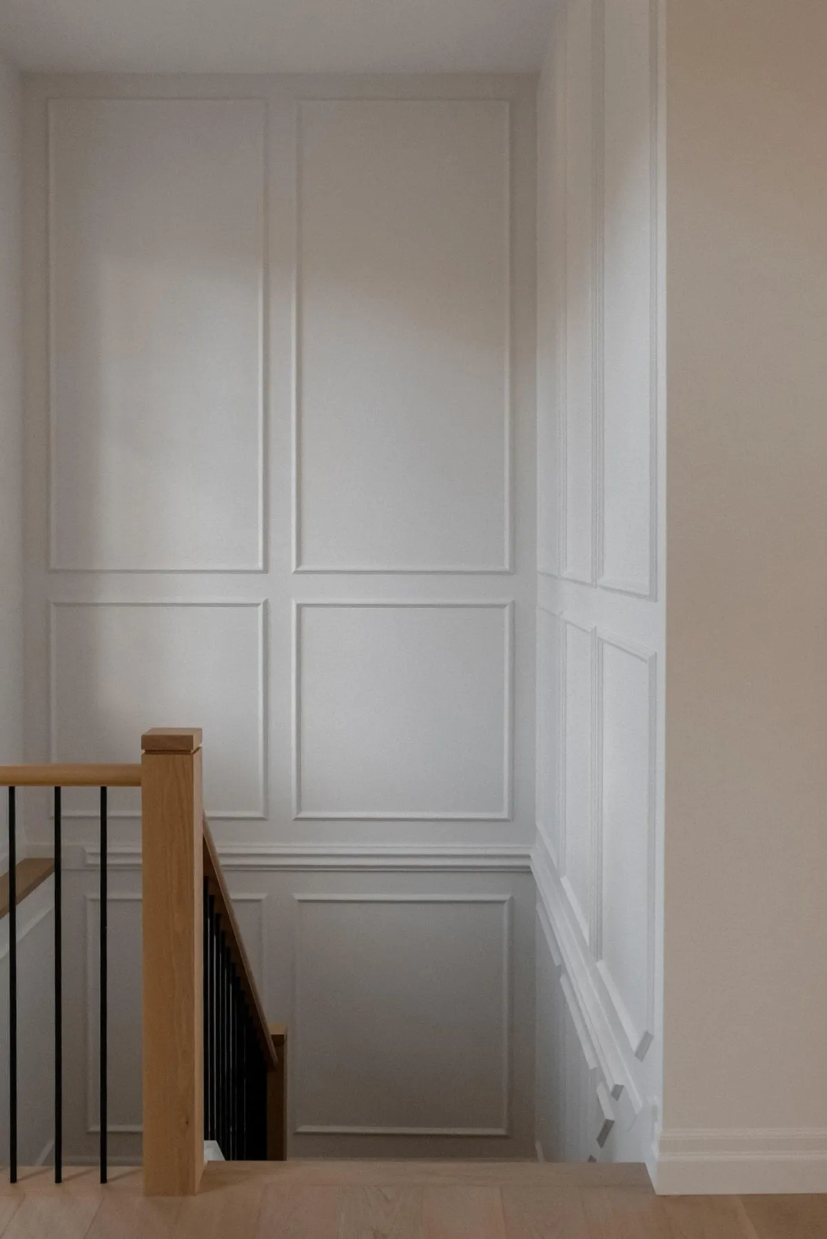 Shadowy entrance to a set of stairs of a beige home interior