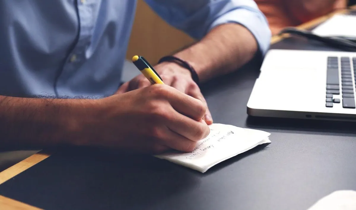 Photo of someone writing at a desk