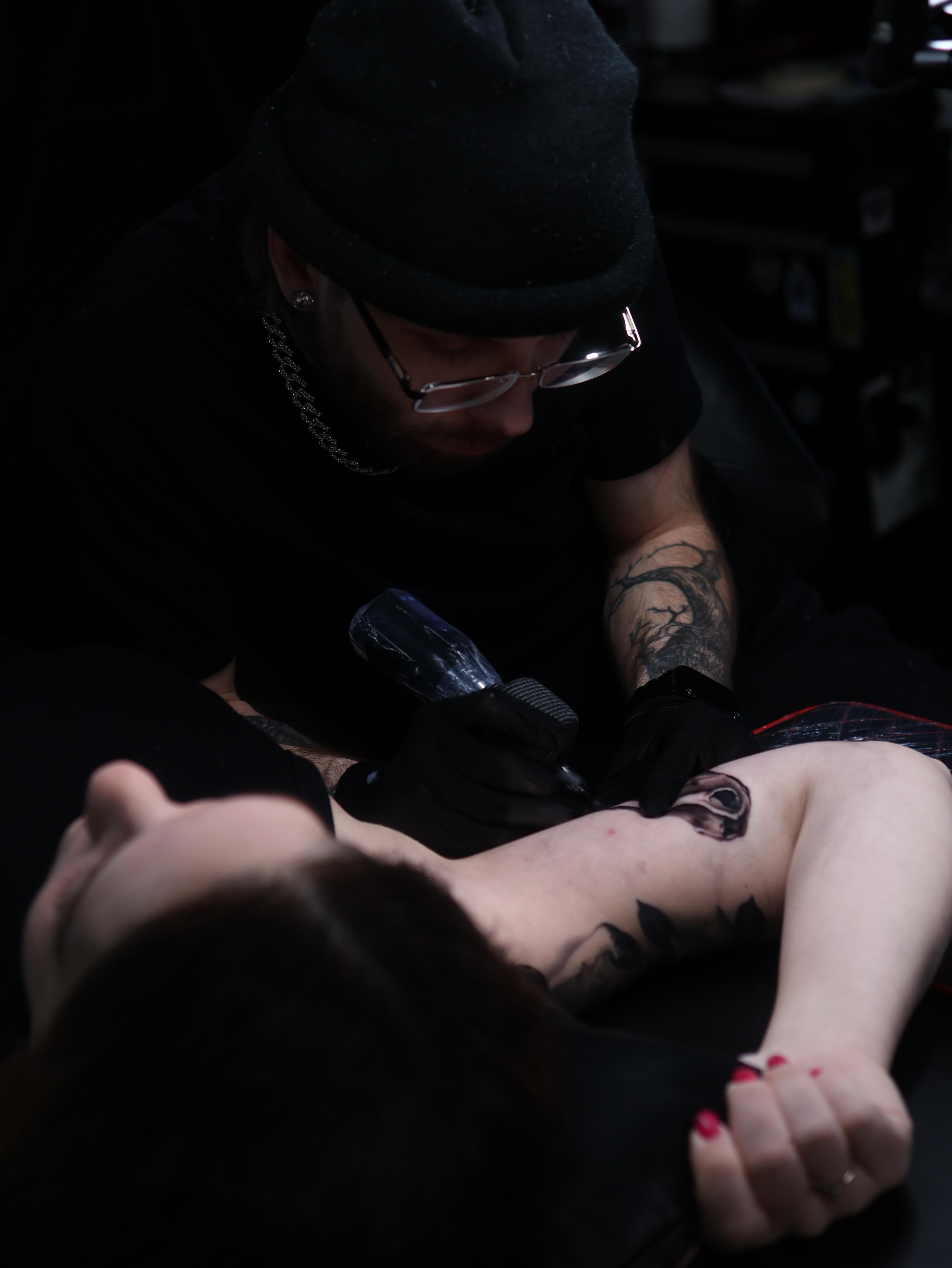 Black and grey surrealism portrait tattoo on the lower leg, featuring a realistic female face emerging through abstract smoke-like shapes, created by a realism and surrealism tattoo artist in Warren, Ohio.