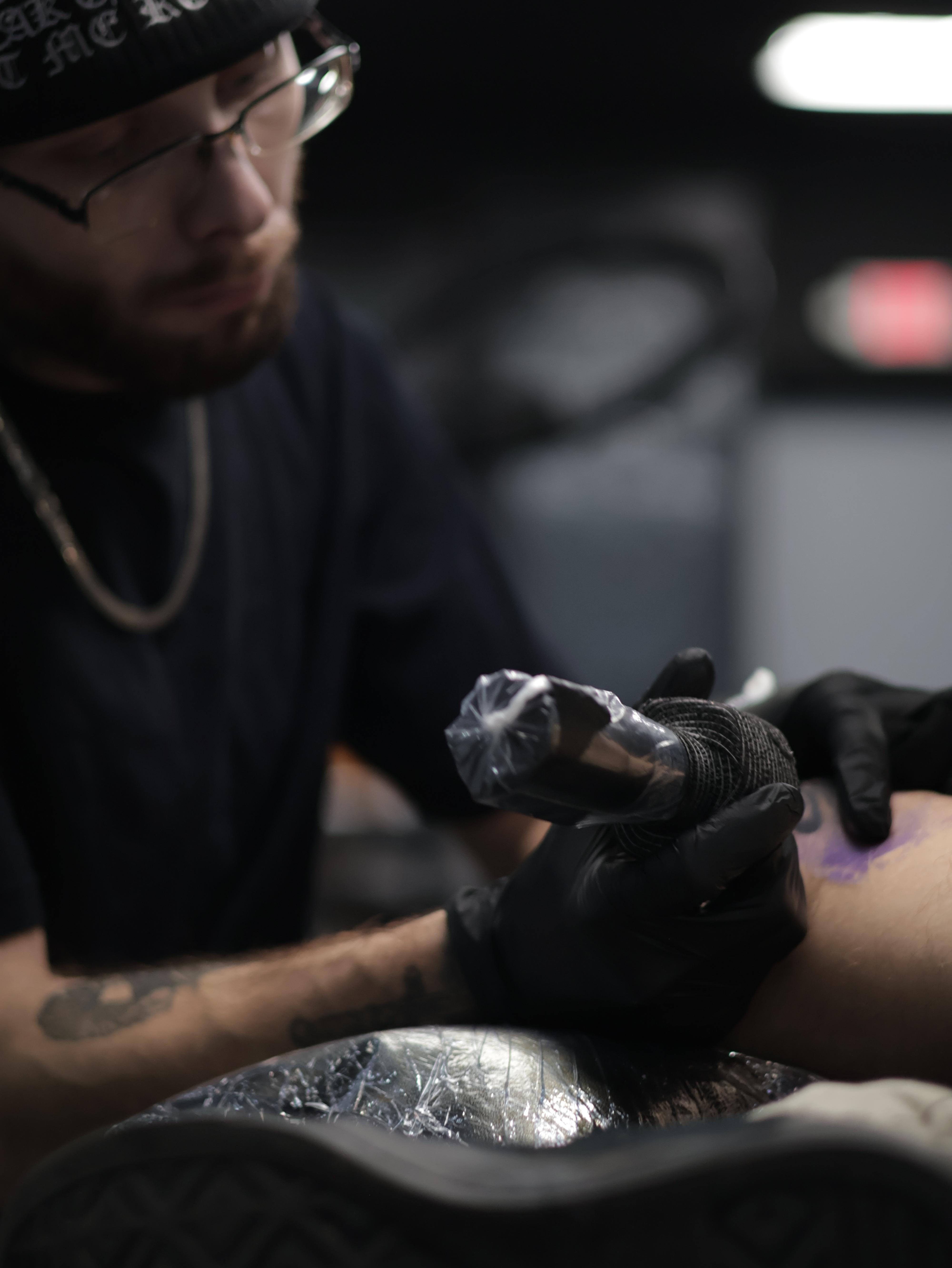 Black and grey realism and surrealism tattoo artist in Warren, Ohio preparing a sterile tattoo workstation and ink setup inside a professional studio before creating a custom high-detail realism tattoo.