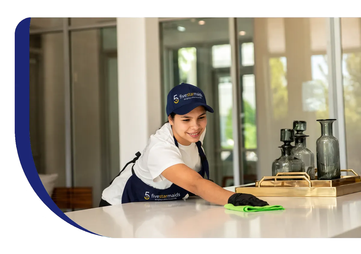 House cleaner wiping kitchen counter during residential cleaning service