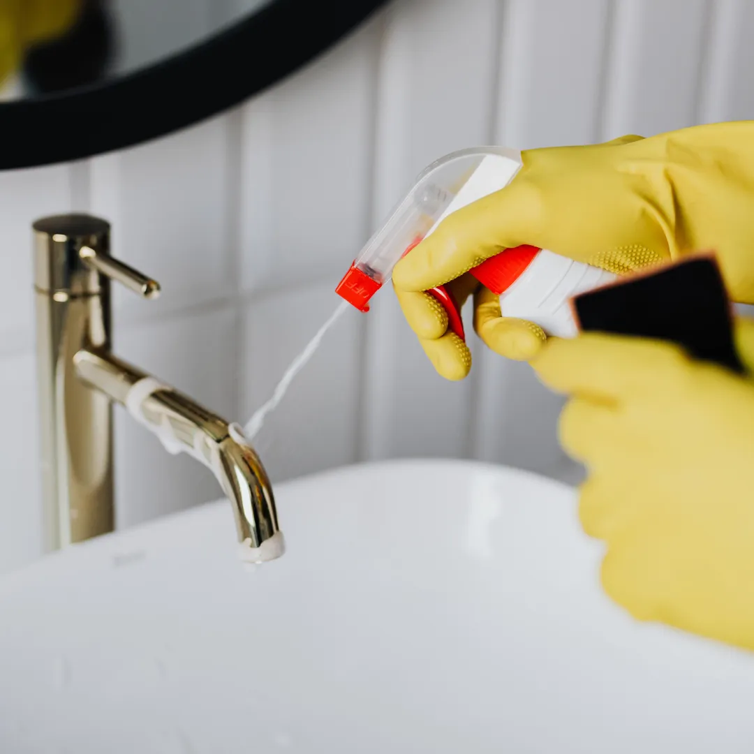 Professional house cleaner wiping a large window during residential cleaning service