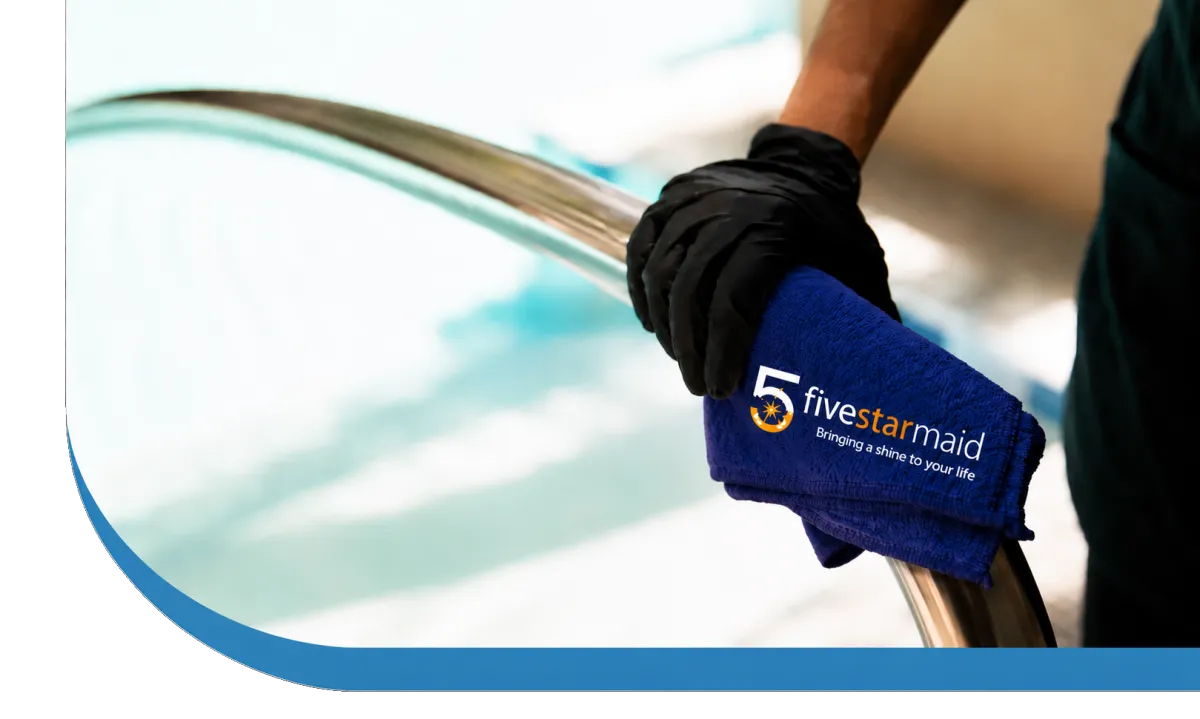 Gloved hand cleaning a swimming pool tile with a sponge