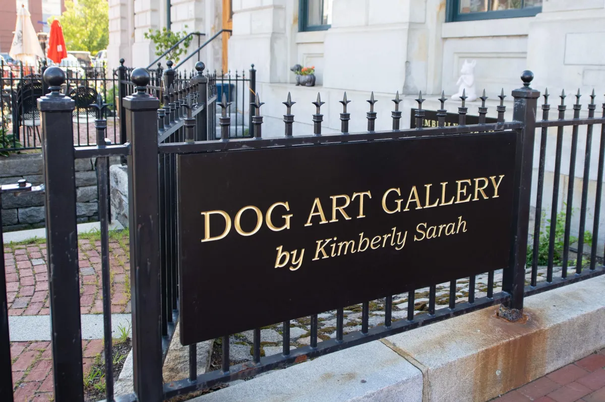 Dog Art Gallery sign, black with gold letters, on the iron fence at Kimberly Sarah Photography at the Customs House in Portsmouth, NH