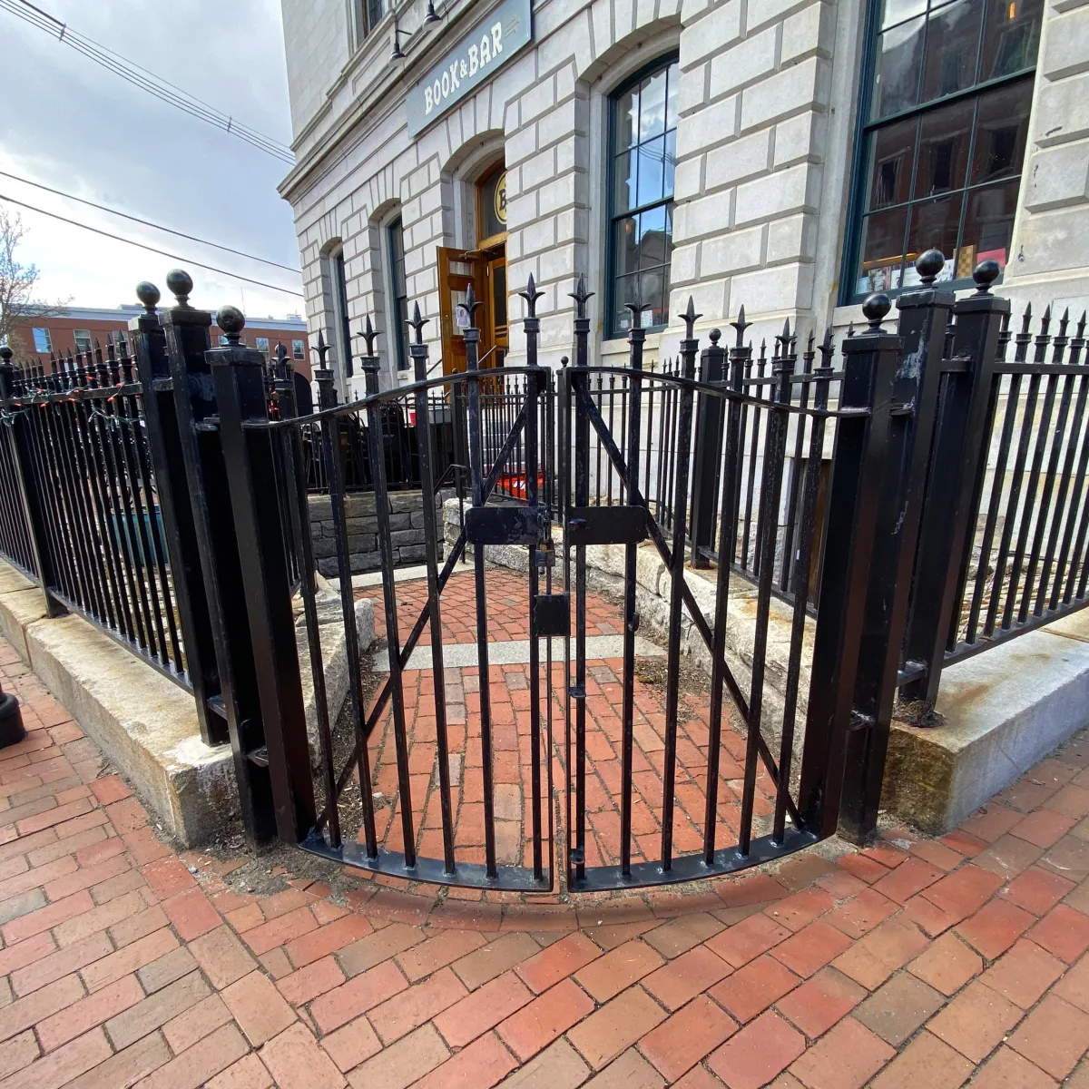 Curved front iron gate in front of Kimberly Sarah Photography and the Dog Art Gallery at the Customs House in Portsmouth NH 