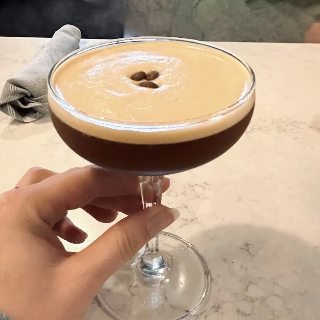 Espresso martini topped with coffee beans, a signature cocktail at Rushing Trading Co. in Sugar Hill, GA
