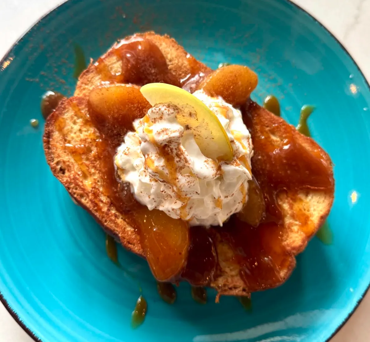 Caramel apple French toast topped with whipped cream and cinnamon at Rushing Trading Co. brunch in Johns Creek, GA