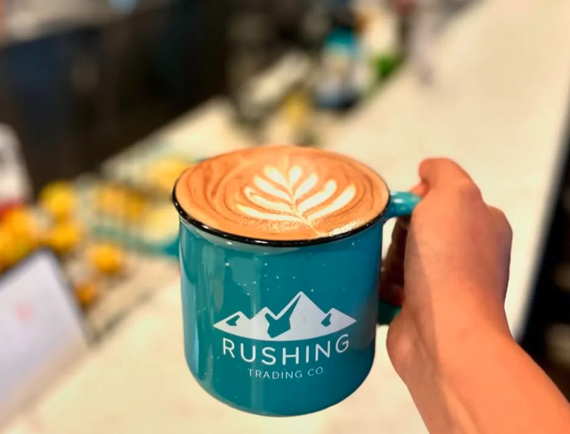 Latte with rosette latte art in a teal Rushing Trading Co. mug at brunch in Johns Creek, GA