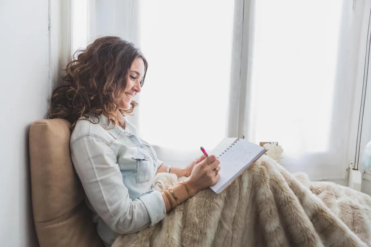 Woman by window reflecting peacefully during emotional healing