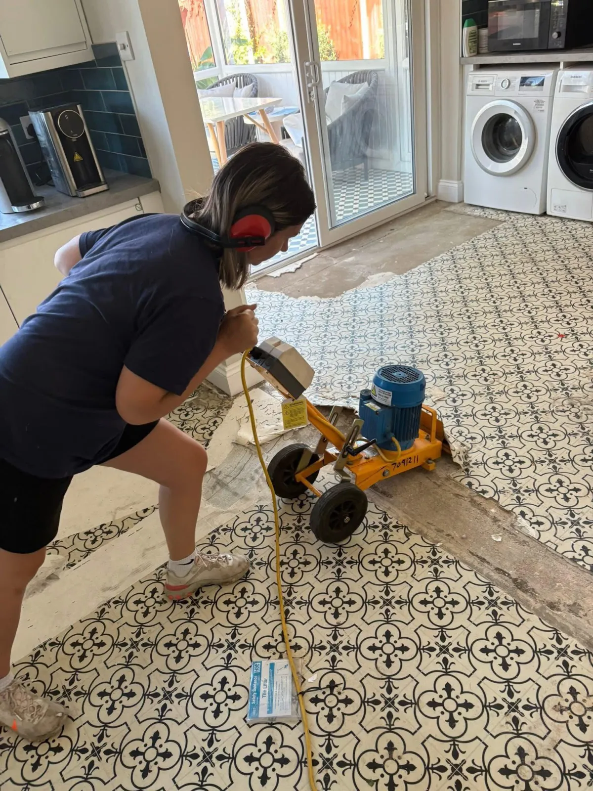 A RLL carpet and flooring staff member removal an old kitchen floor