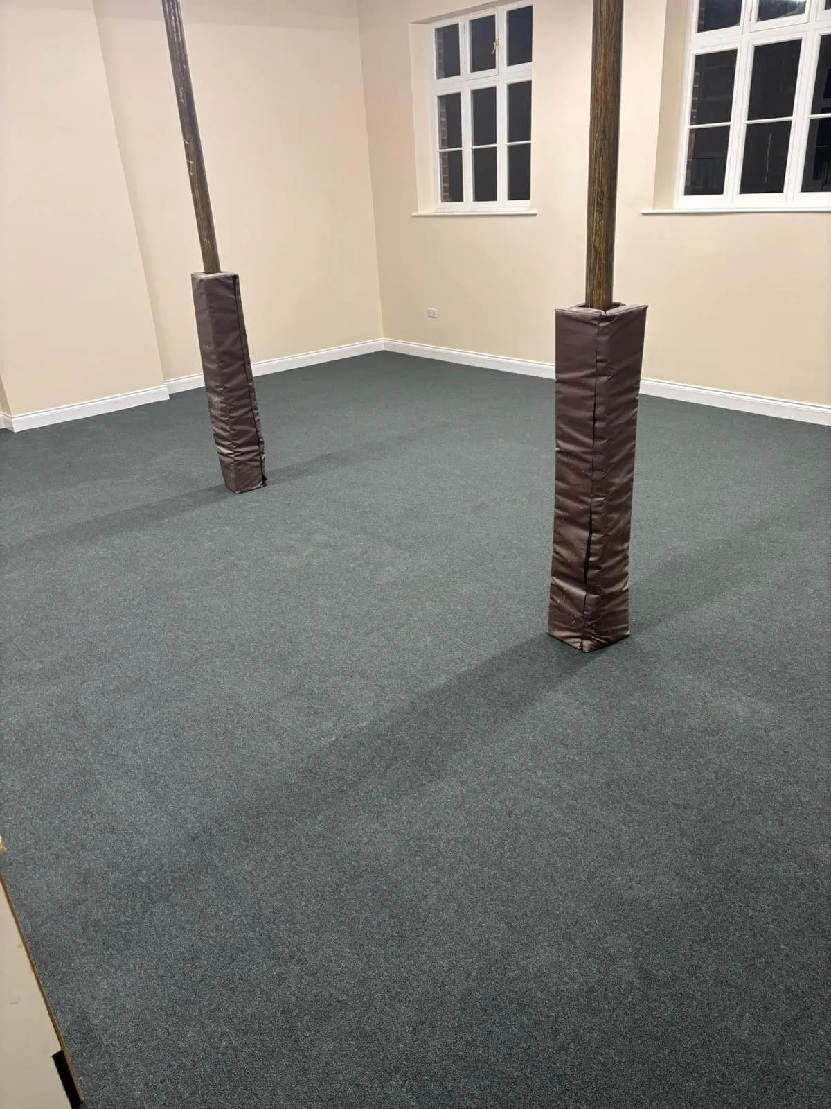 A close-up image of freshly fitted carpet tiles in a shade of grey