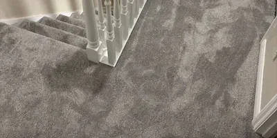 Grey plush carpet at the top of a staircase