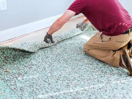 A RLL Carpet and Flooring team member installing carpet underlay