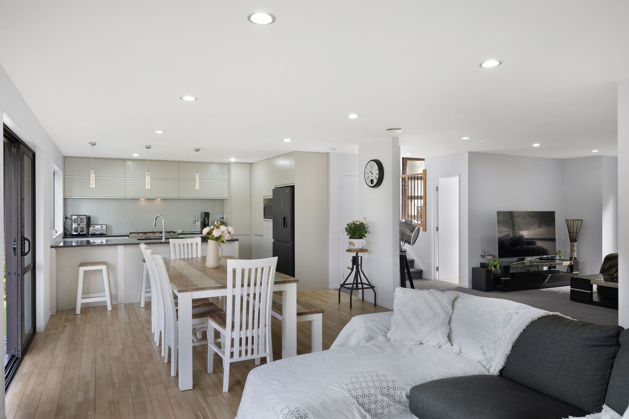 real estate photo of an open plan kitchen, dining, and lounge area