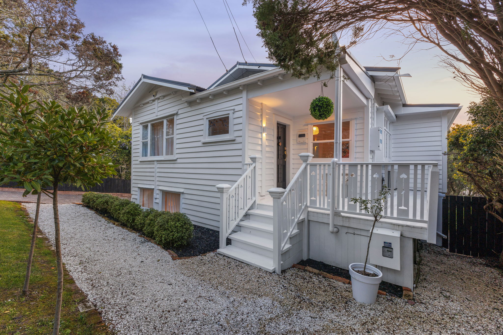 Real dusk photography of Auckland property at golden hour showing warm interior lights and glowing sky by Bash & Co