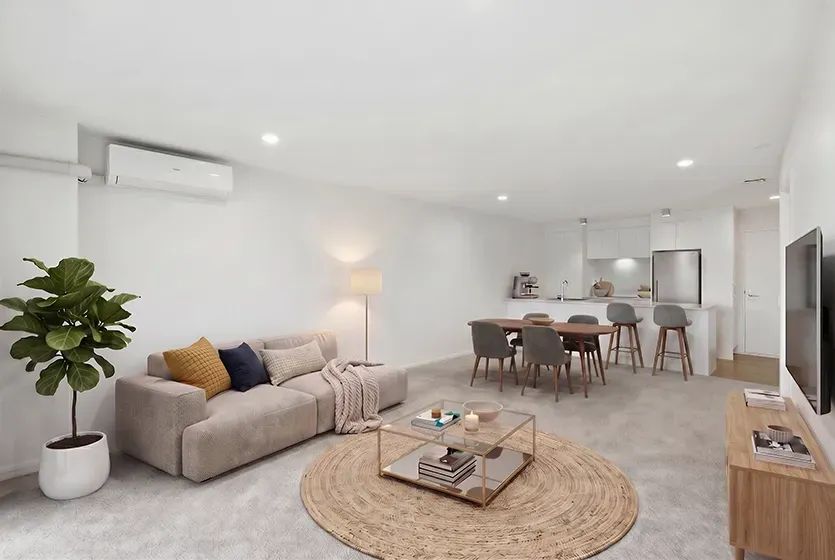 virtually staged living room space with a couch, rug, coffee table and dining table