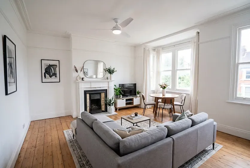 virtually staged living room photo with a couch fireplace and ceiling fan