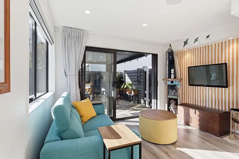 real estate photo of a lounge leading to an outdoor deck