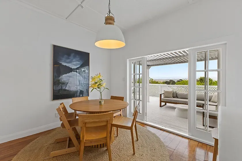 real estate photo of a dining room flowing to an outdoor deck