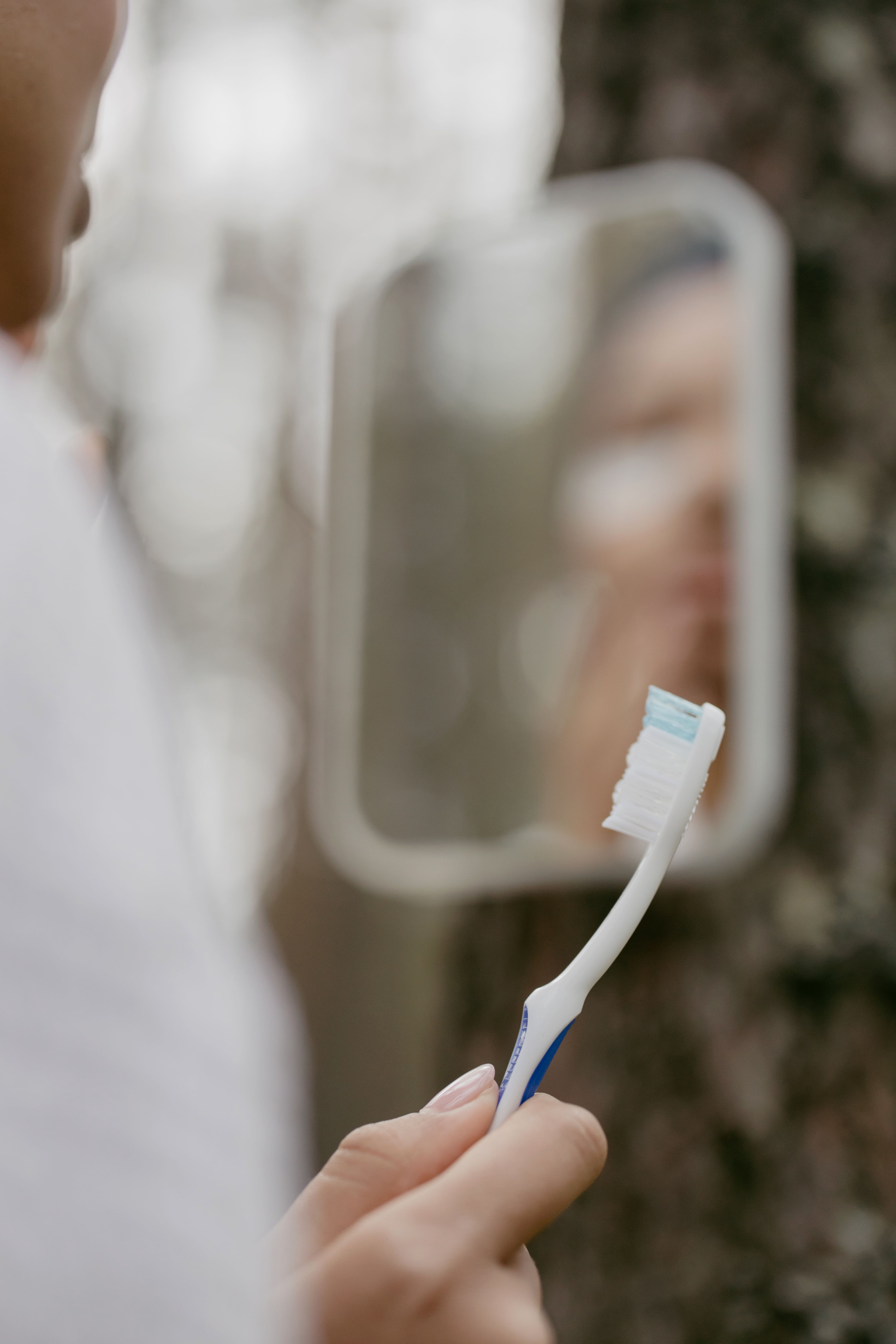 Looking in mirror with toothbrush
