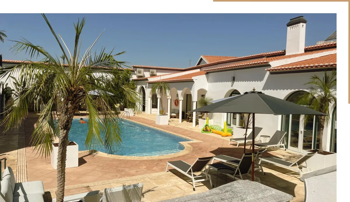 Vista deslumbrante para a piscina do Solar dos Frades, rodeada por um ambiente tranquilo e acolhedor, ideal para momentos de relaxamento.