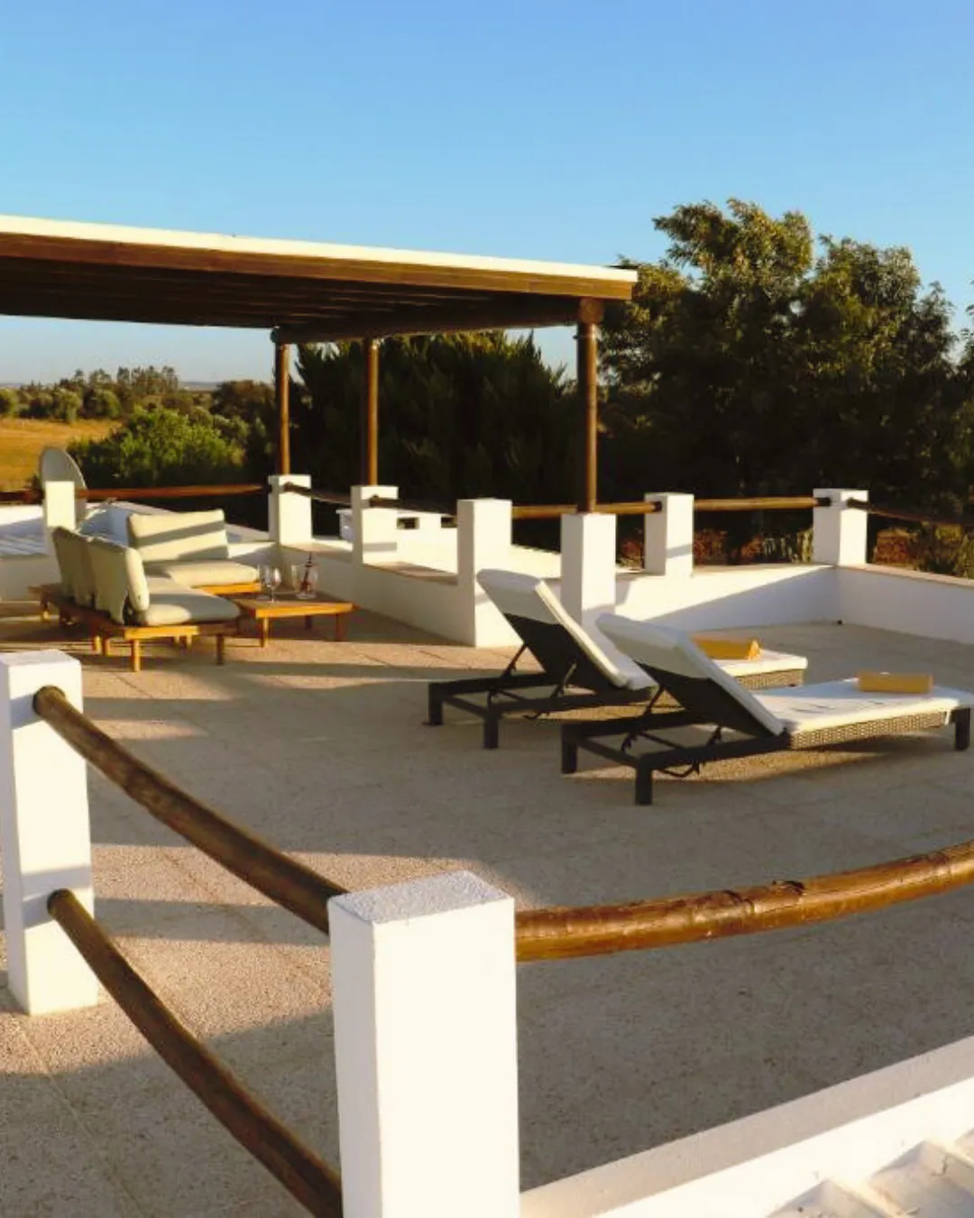 "Espreguiçadeira no terraço do Monte da Figueira Brava, oferecendo um local perfeito para relaxar ao sol enquanto aprecia a vista panorâmica do Alentejo em um ambiente tranquilo e confortável.