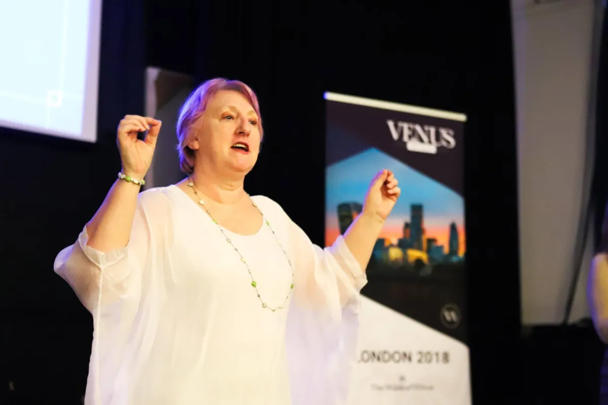 Bev Hepting, award-winning TEDx speaker and coach, passionately engaging an audience during a presentation at the Venus Awards event in London, showcasing her expertise in public speaking and empowerment.