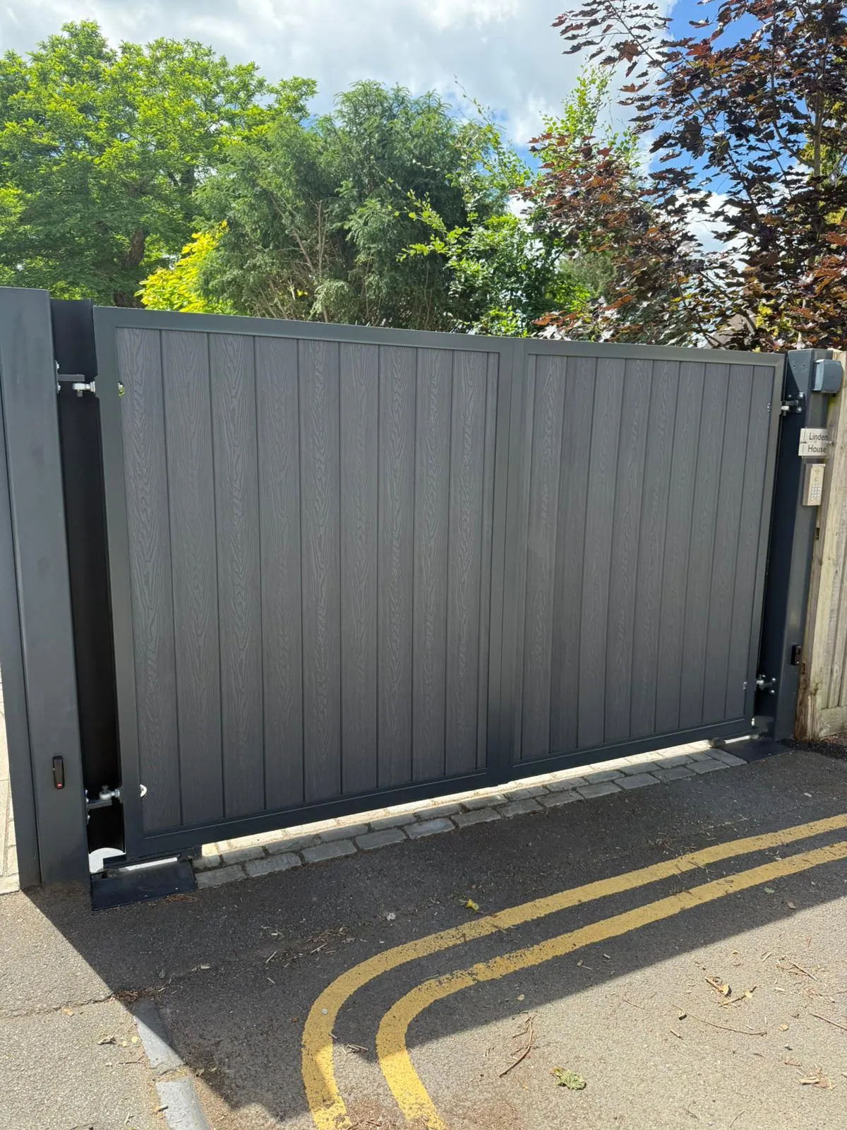 Modern driveway gate with steel frame and anthracite grey boards