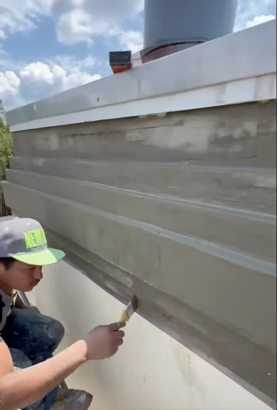 Man painting stucco onto a chimney