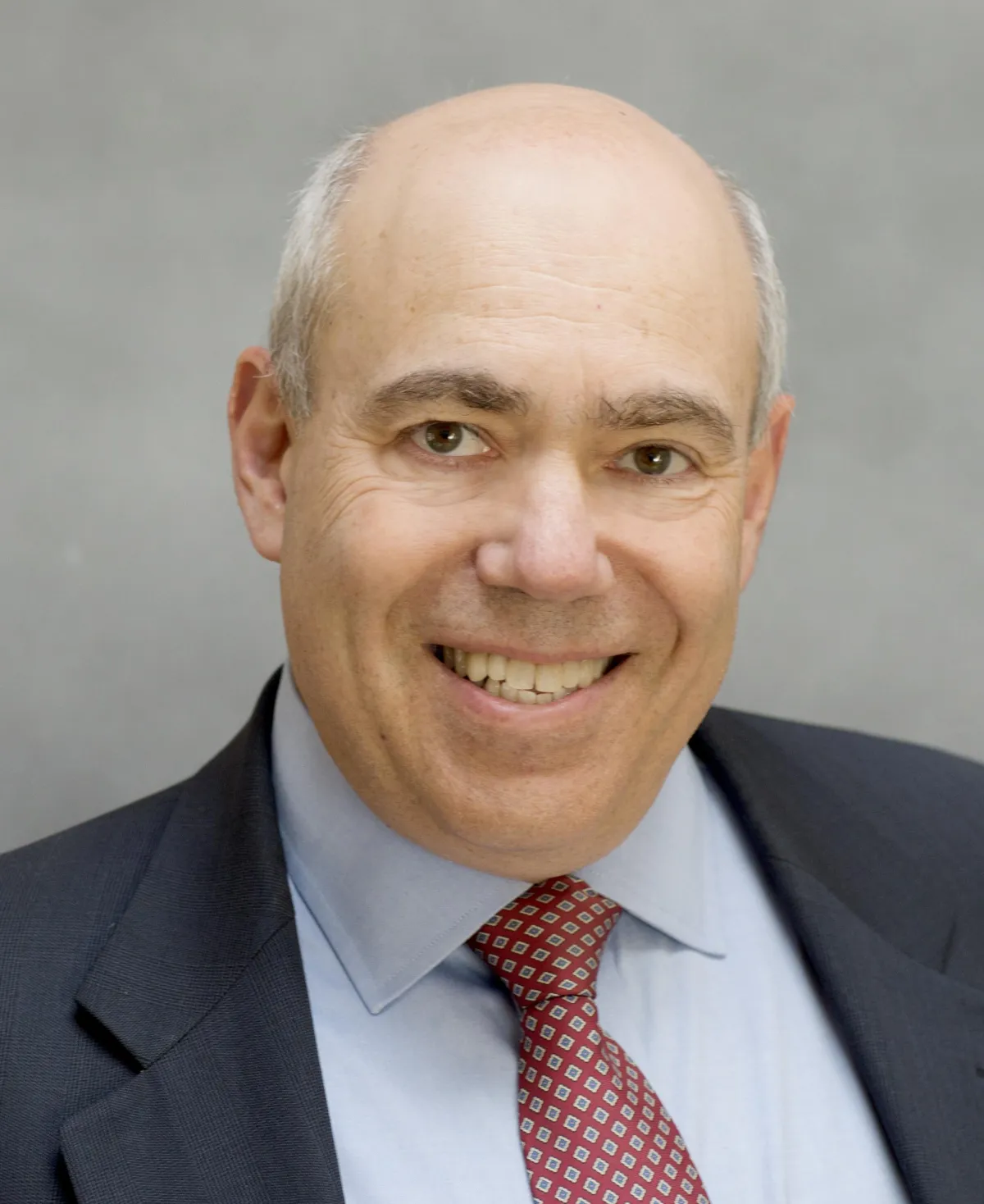 Smiling man in business suit and tie headshot.