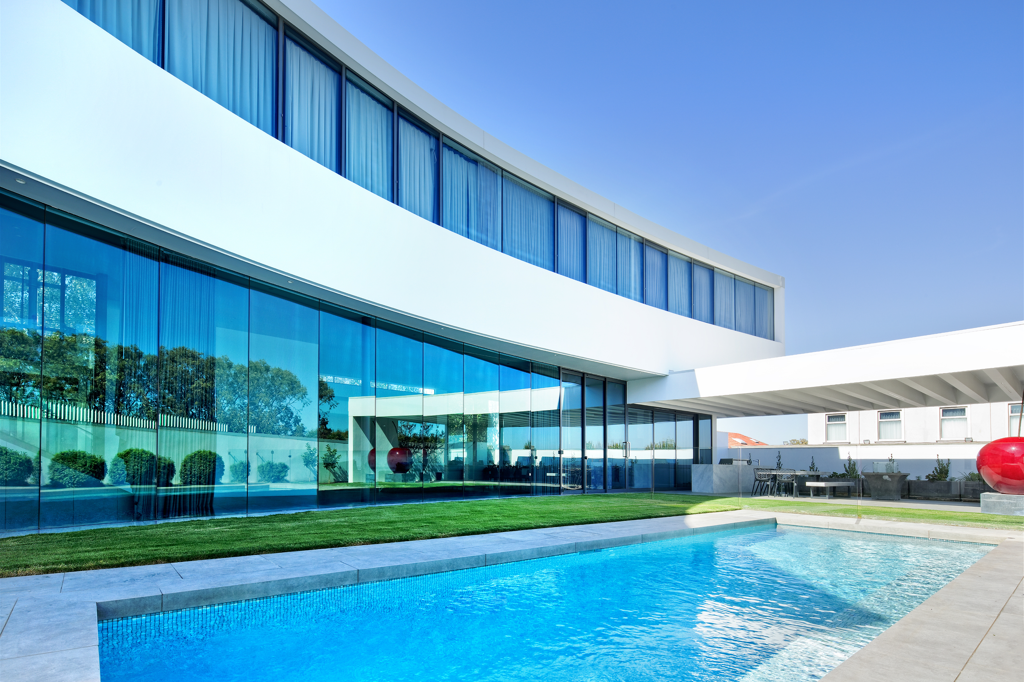 Modern house with two black garage doors under blue sky