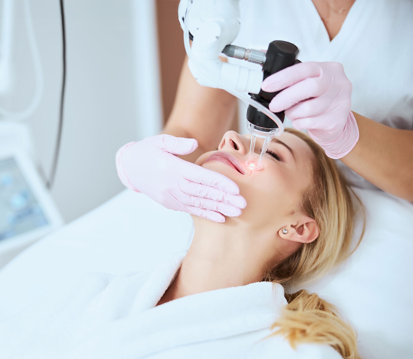 person holding clear glass bottle