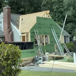 Home addition framing going up on a cape-style house in Worcester, MA by ARM Construction
