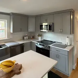 Remodeled kitchen with gray shaker cabinets and quartz countertops in Holden, MA by ARM Construction