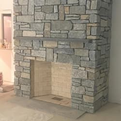 Custom dry-stack stone fireplace and chimney breast built in Holden, MA by ARM Construction