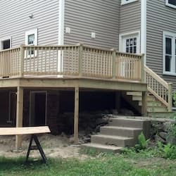 Elevated pressure-treated deck with railing and stairs built in Princeton, MA by ARM Construction