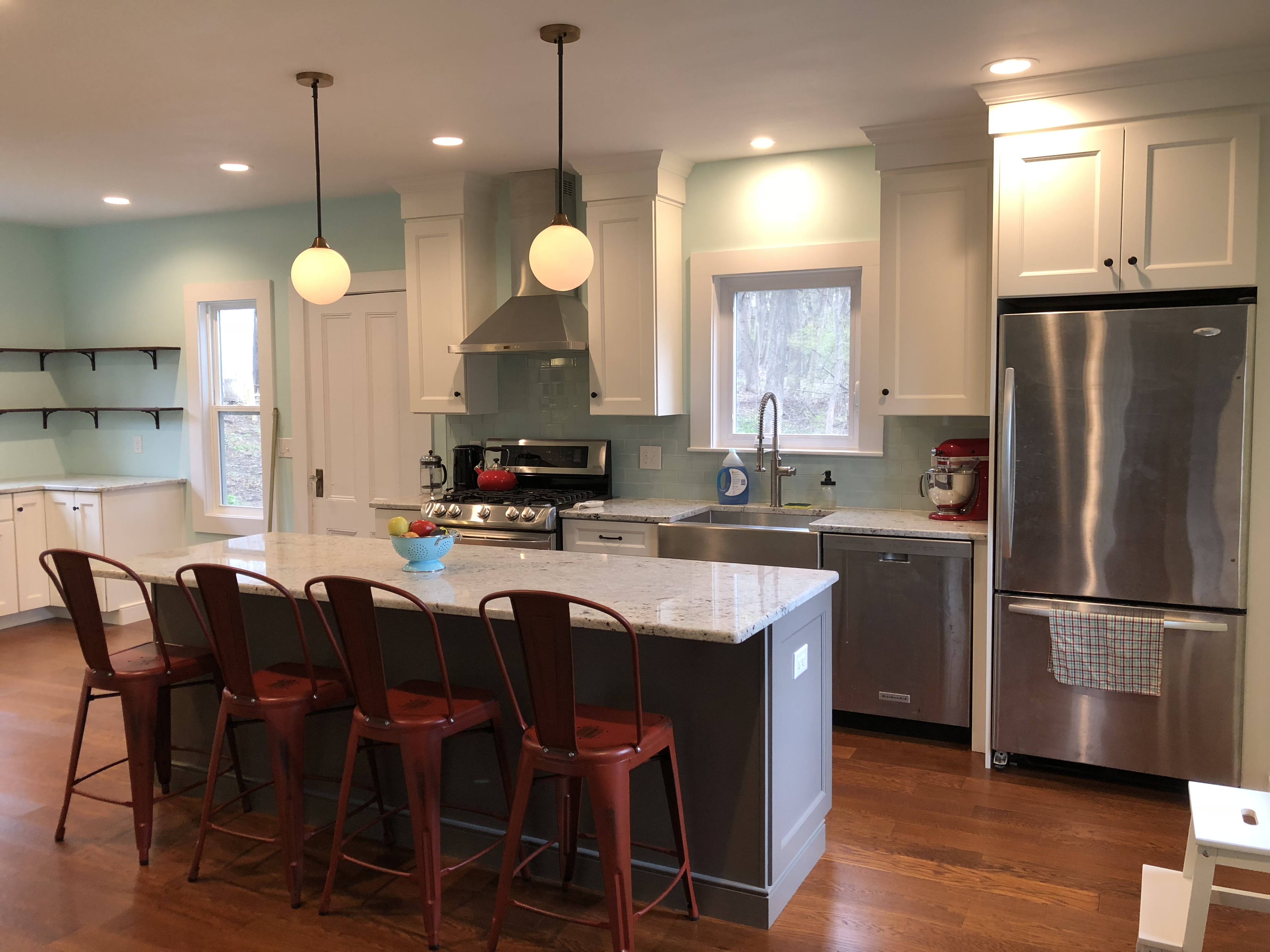 Remodeled kitchen with gray shaker cabinets and quartz island by ARM Construction in Worcester County, MA