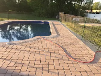 Paver pool deck surrounding an in-ground pool, installed by ARM Construction in Leominster, MA