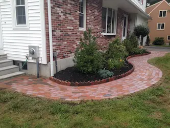 Curved brick paver walkway with soldier course border, installed by ARM Construction in Princeton, MA