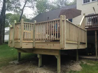 Pressure-treated deck with railings and stairs, built by ARM Construction in Grafton, MA