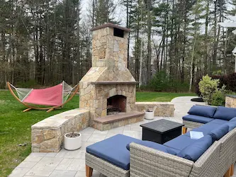 Outdoor stone fireplace and bluestone patio, built by ARM Construction in Southborough, MA