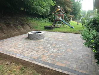 Paver patio with a stone fire pit, built by ARM Construction in Sterling, MA