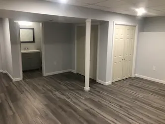 Finished basement with luxury vinyl plank flooring and a half bath, by ARM Construction in Northborough, MA