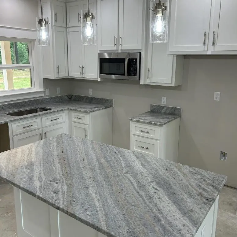 Remodeled gray and white kitchen with white cabinets and pendant lights over an island