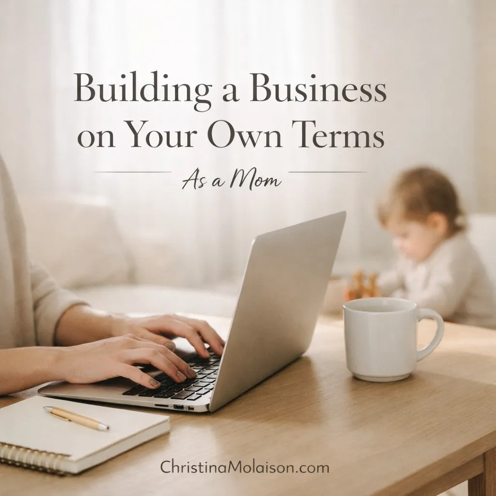 Woman building a flexible business from home as a mom, working on a laptop in a peaceful environment with her child nearby, illustrating entrepreneurship, work-life alignment, and intentional business design.