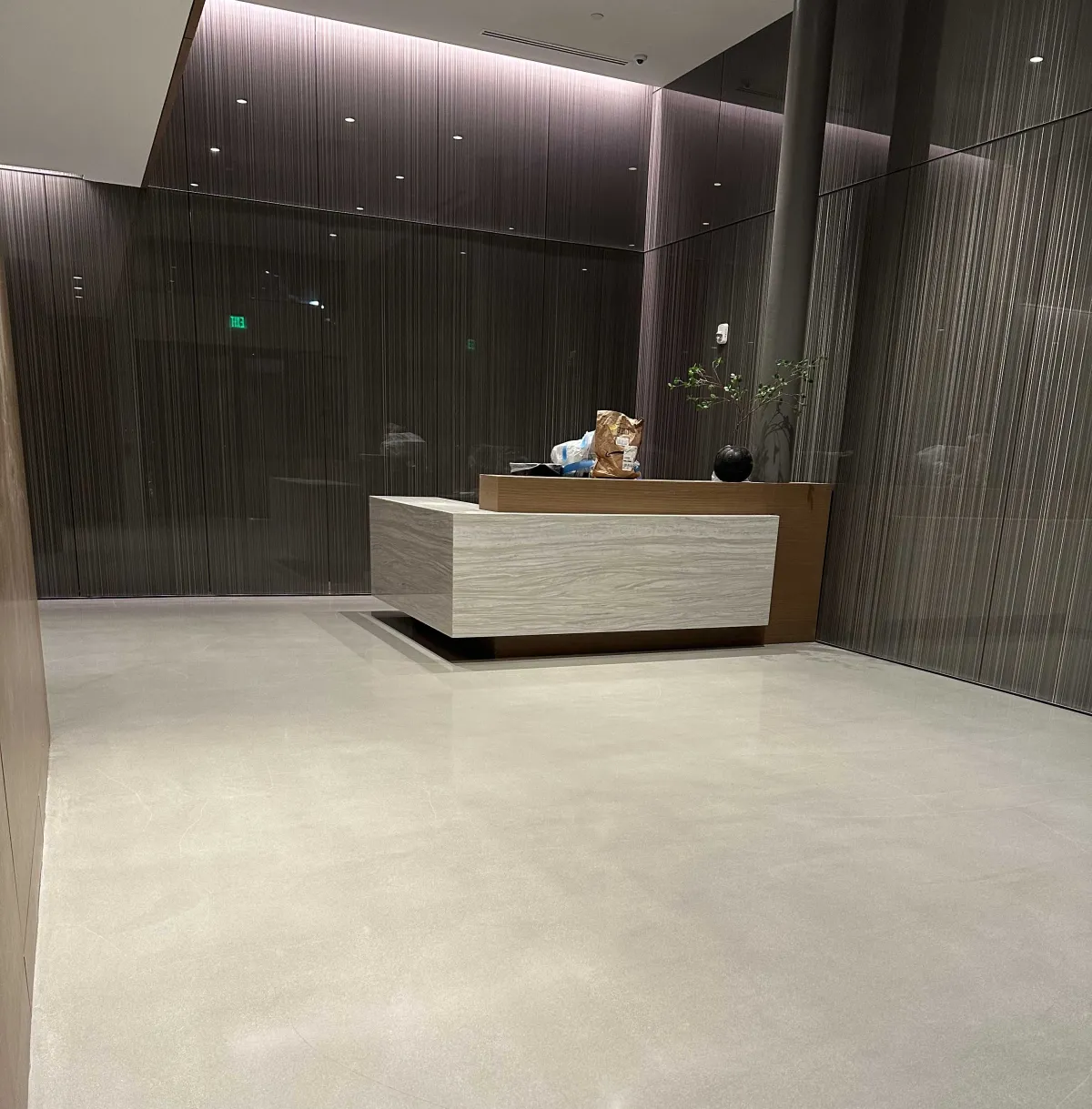 Close-up of a skilled technician in uniform applying epoxy coating to a commercial floor using a roller, with attention to detail and a clean, organized workspace. The image conveys professionalism and expertise in floor finishing.