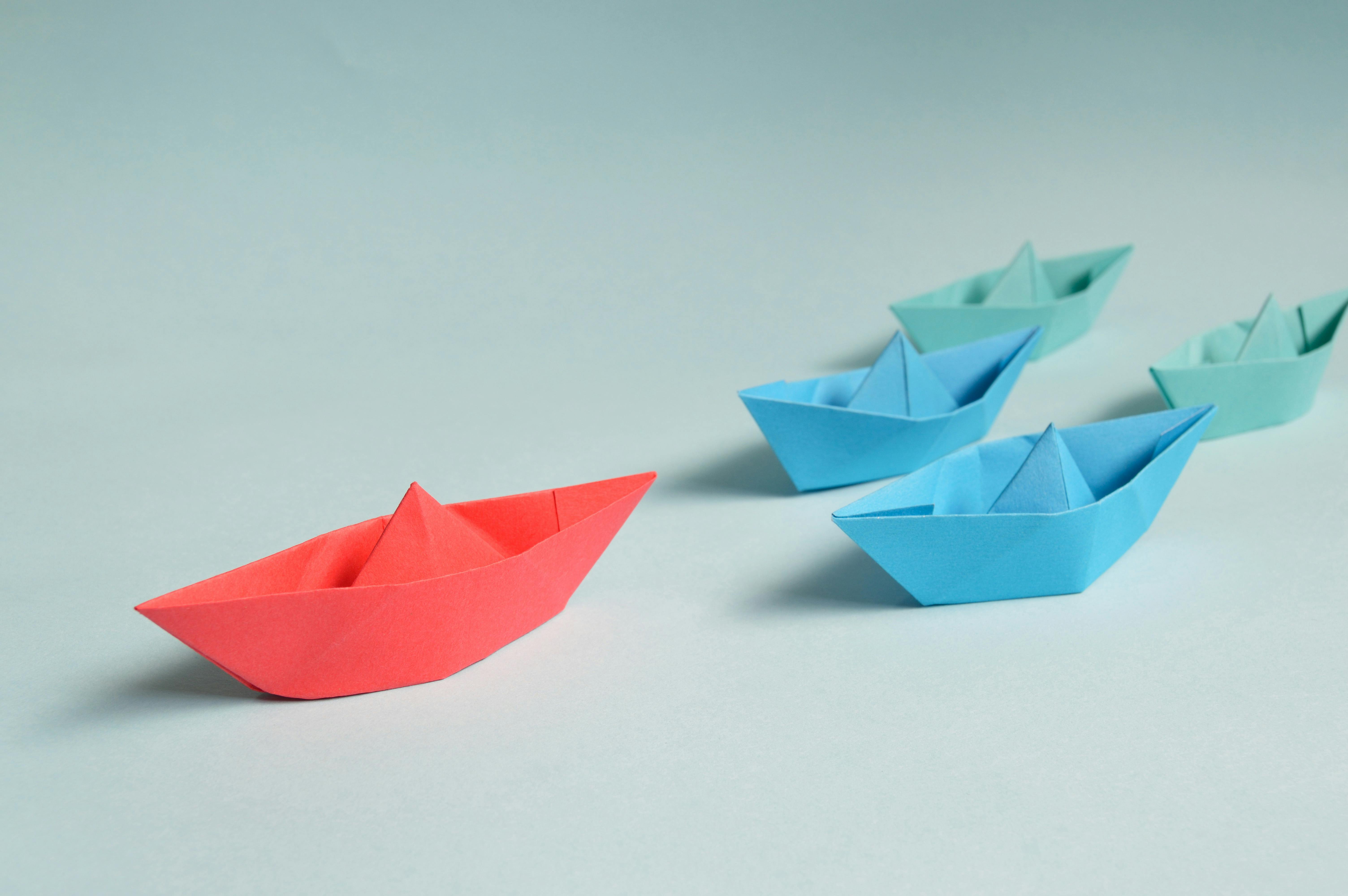 Paper boats following the lead Photo by Miguel Á. Padriñán: https://www.pexels.com/photo/paper-boats-on-solid-surface-194094/