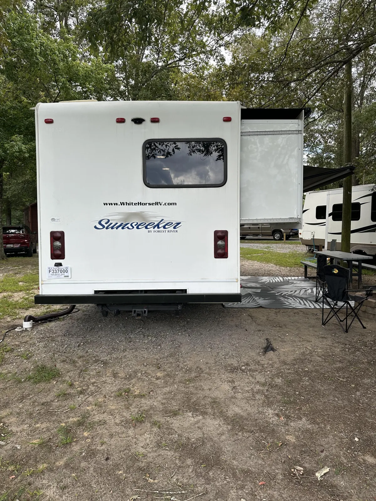 Rear view of a 2016 Forest River Sunseeker 2700DS Ford Class C RV parked at a campsite with slide-out extended and outdoor seating area.