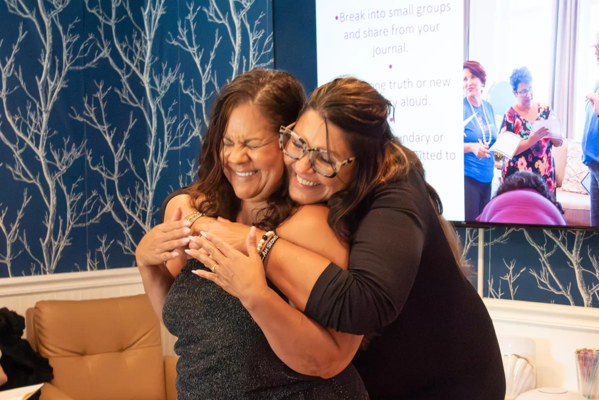 women smiling and hugging